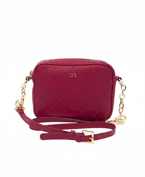 A burgundy quilted leather crossbody camera bag with gold-tone hardware, a matching burgundy strap, and a gold 'DR' logo on the front, shown against a plain white background.