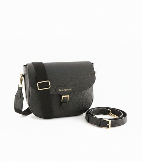 A black pebbled leather crossbody bag with gold-tone hardware, shown with its detachable shoulder strap on a plain white background. The brand name 'Denoë Roman' is embossed on the front flap.